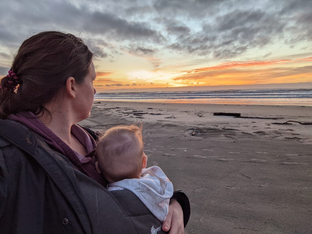 Mom with baby on the beach at sunset