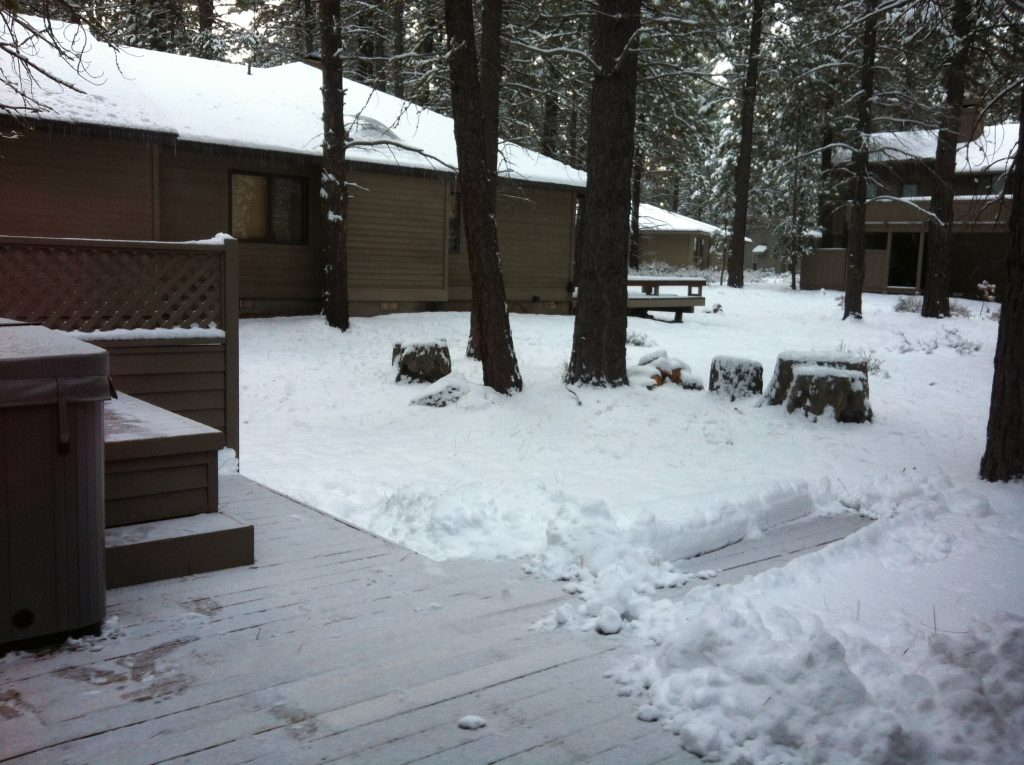 snowy cabin with outdoor hot tub